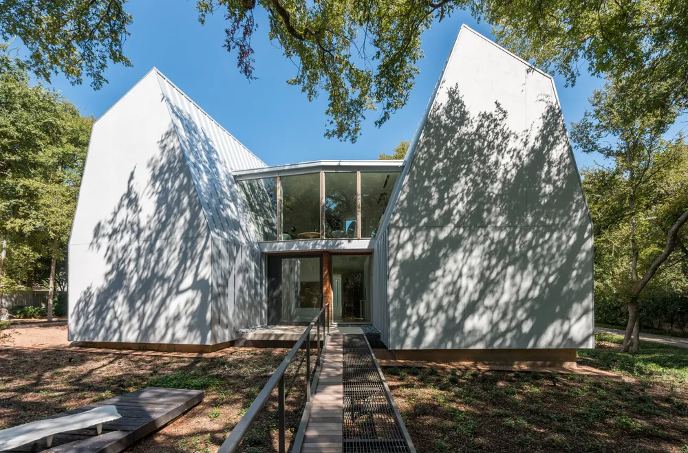 Finished SIP residence with white gabled forms, built from precut panels